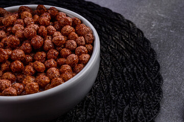 Detail of bowl with chocoball cereal on table ready for breakfast.
