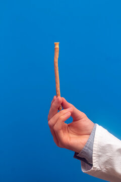 Guy hold miswak on blue background. Teeth cleaning. Sunnah teeth brushing. Sivak.