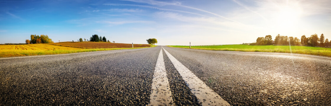 Wide asphalt road panorama in countryside on summer day.