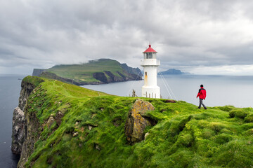 Fototapeta na wymiar Foggy view of old lighthouse on the Mykines island, Faroe islands, Denmark. Landscape photography