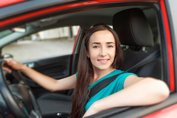 Fototapeta na wymiar Happy beautiful woman is driving a car.
