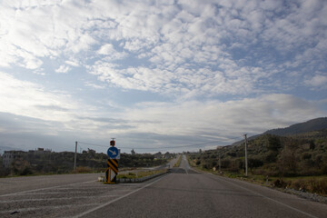 Obraz premium road to the horizon, trees and power poles by the roadside, clouds in the sky