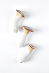 Fototapeta premium Collage of fresh whole and chopped eringi mushrooms isolated on white background. View from above