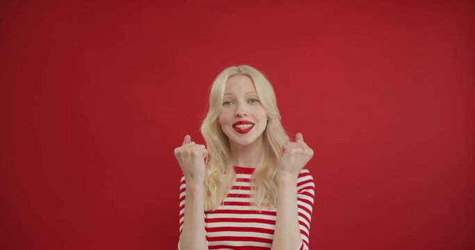 Closeup of extremely excited woman cant believe in happiness, surprised and satisfied with lottery victory, happy woman dance, looking at camera with amusement. Studio shot isolated on red background
