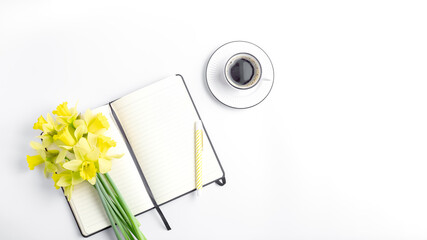 femine workspace long banner. white work desk with coffee mug, notepad, pen and spring flower. simple flat lay, copy space