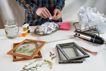Making postcards from paper waste and decorating them with dried plants. Do it yourself. Step by step. Step 2. Shredding the paper into small pieces. Zero waste..
