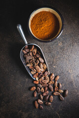 Naklejka premium Cocoa powder and cocoa beans in scoop.