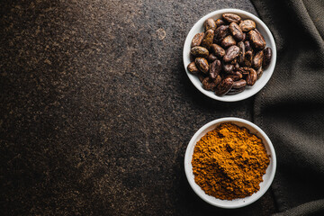 Cocoa powder and cocoa beans in bowl.
