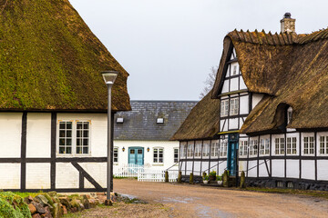 Traditional old country houses with thatched straw roof on street in Denmark