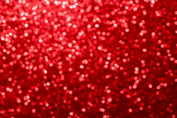 Red glitter foil Christmas background. Shiny metal red foil texture abstract defocused background. Sparkle glitter texture with bokeh lights