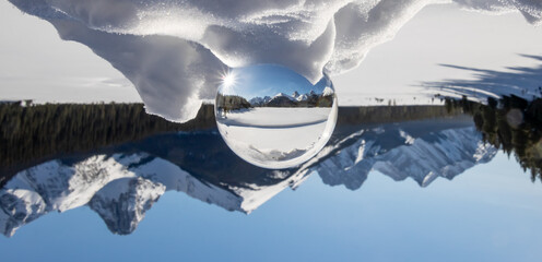View of a scenic snow peaked mountain range in a lens ball with the mountain range inverted in...