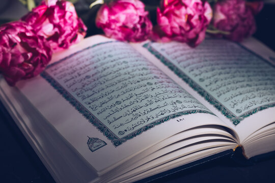 Kazan, Russia - 03 March 2021. Holy Quran on a black background with flowers. Tulips. Ramadan. Reading the Quran. Ramadan concept.
