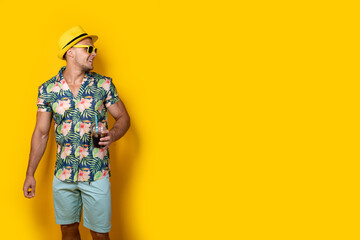 Man in bright clothes with beverage on yellow