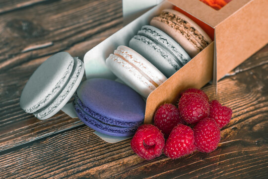 Cardboard box with macaroon cookies and raspberries, a favorite treat for children