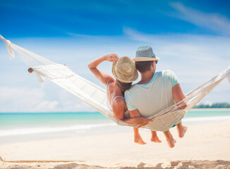 Young couple in love relaxing in a hammock by the beach