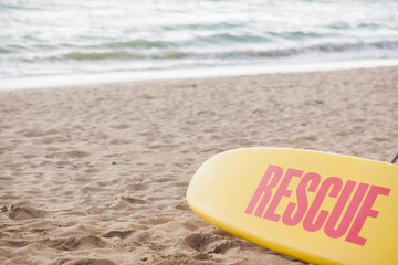 Yellow surf rescue board by the sea beach.