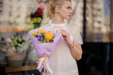 elegant bouquet with yellow ranunculus flowers in hands of woman