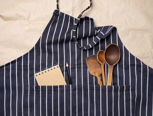 blue chef's apron, inside a pocket of wooden spoons