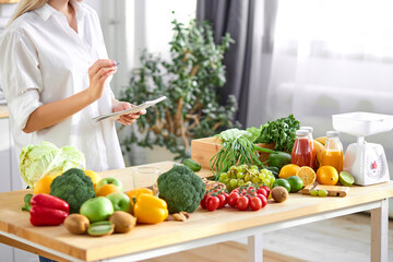 cropped young woman nutritionist standing near table full of healthy products in office