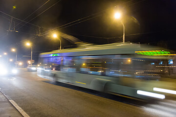 Fototapeta na wymiar The movement of blurred trolleybus along the overpass in the evening. Photographed with a long exposure.