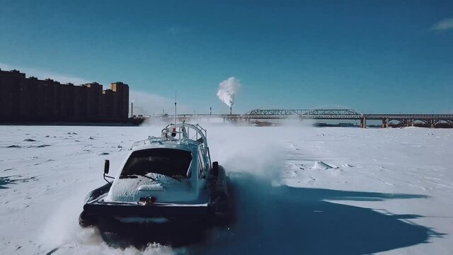 Aerial photography: Hovercraft rides on an ice-covered river in winter
