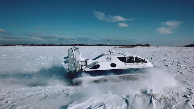 Aerial photography: Hovercraft rides on an ice-covered river in winter