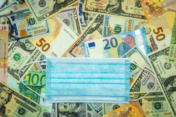 Fototapeta na wymiar Medical mask and banknotes of the countries of the world. Travel and business during the coronavirus pandemic
