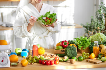 unrecognizable female in bathrobe enjoy making and eating fresh salad from vegetables