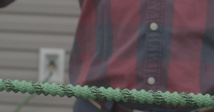Male stretching a brand new expandable garden hose.