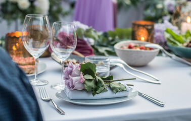 Mesa preparada y decorada para banquete de boda con mantel, servilletas, cubertería y arreglos florales