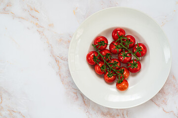 Red, ripe tomatoes on a white marble background.Top view with copy space.