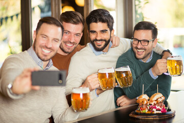 Fototapeta na wymiar Group of happy friends have a fun in beer pub