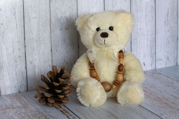 teddy bear with wood necklace and cone 