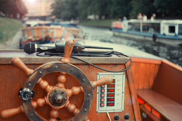 The steering wheel of a wooden pleasure boat before going on an excursion in St. Petersburg before the opening of the season 