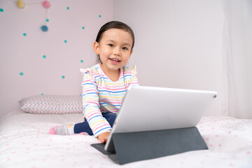 Portrait of a toddler girl using digital tablet.