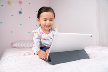 Girl child watching content in digital tablet.