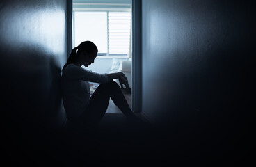 Exhausted, tired and sad woman sitting on bedroom floor