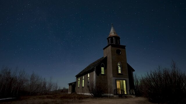 Stars move slowly through the sky behind a dilapidated church. Light can be seen through the broken door and windows. Weak Aurora occur at the end of the video. 
