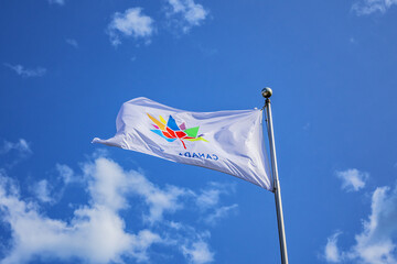 A Canadian flag with an inscription 'Canada 150' with maple leaf fluttering against the blue sky.