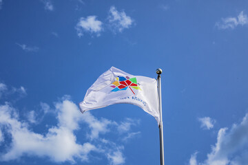 A Canadian flag with an inscription 'Canada 150' with maple leaf fluttering against the blue sky.