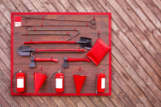 fireman shield with fire fighting and safety tool, hanging set of fighting tools on a wooden wall, nobody.