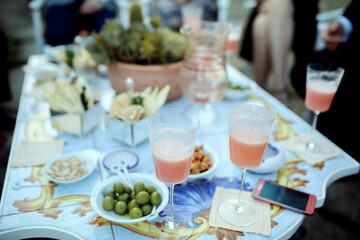 romantic and beautiful table with snacks and drinks, phone, olives, other delicious meal in the restaurant