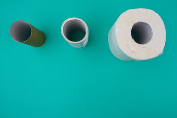 Three stages of toilet paper. A sleeve, a sleeve with some toilet paper, and a whole roll of toilet paper.