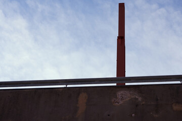 Fototapeta premium A metal pillar on a concrete bridge against the sky.