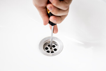 handyman repairing or cleaning clogged sink drain at bath. plumber service concept