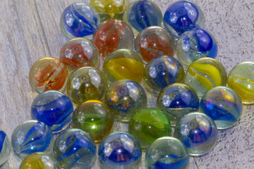 Blu, red, green, yellow glass marbles on clear background