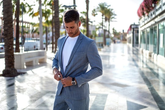 Fototapeta Handsome italian man walking on the city street wearing elegant fashionable suit.