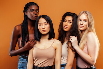 Fototapeta premium young pretty asian, caucasian, afro woman posing cheerful together on brown background, lifestyle diverse nationality people concept