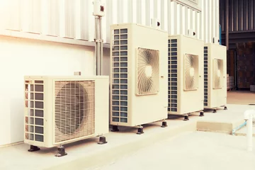 Fotobehang Condenser unit or compressor outside industrial plant building. Unit of central air conditioner (AC) or heating ventilation air conditioning system (HVAC). Electric fan and refrigerant pump inside. © DifferR