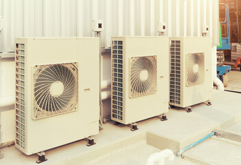 Condenser unit or compressor outside industrial plant building. Unit of central air conditioner...